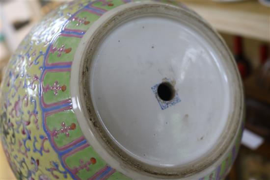 A Canton enamelled bottle vase, decorated flowers, foliate scrolls and Chinese characters on a yellow ground, height 40cm, faults